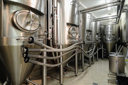 Male manufacturer carrying keg in brewery